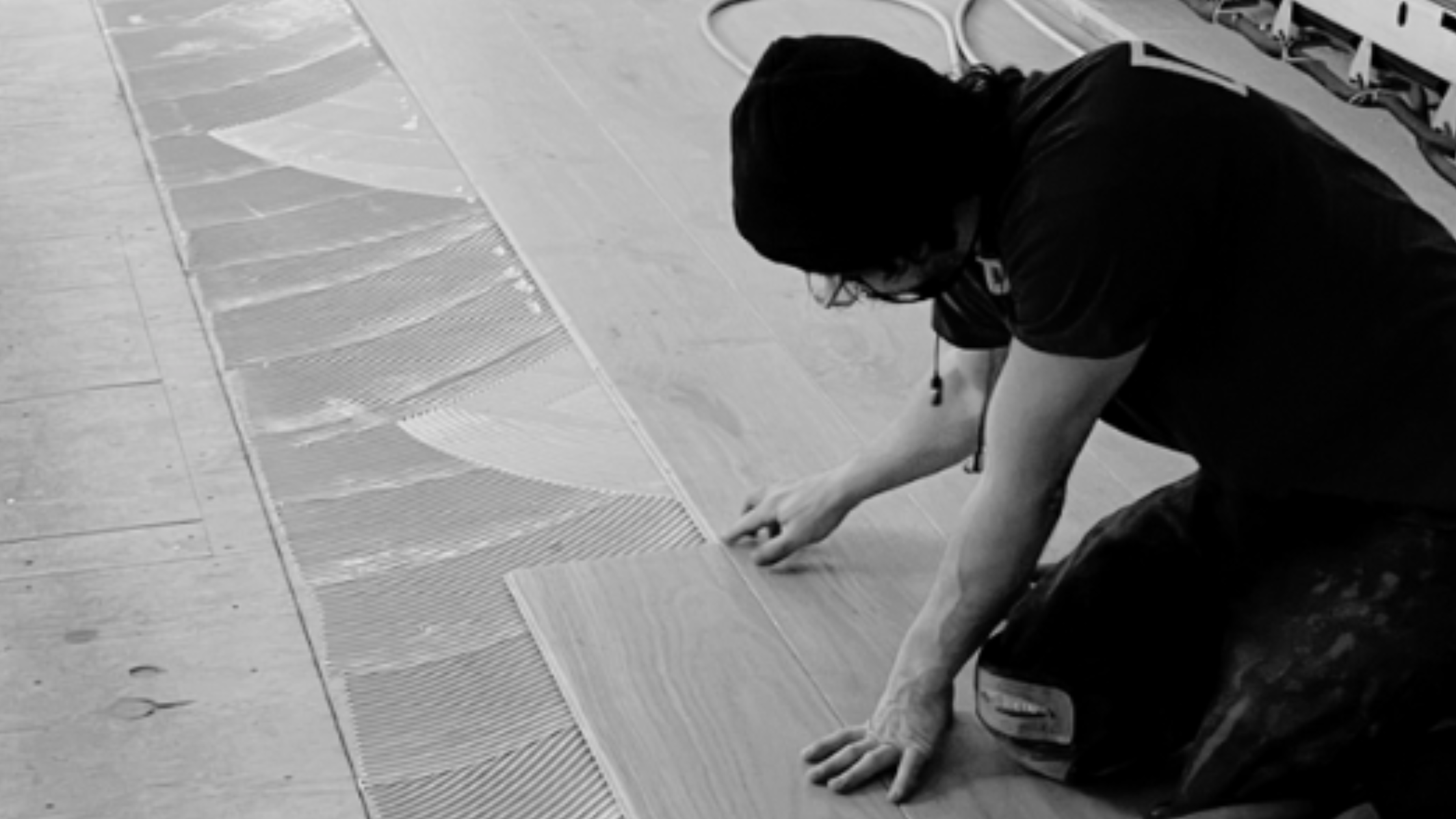Craftsman installing real hardwood flooring by hand, highlighting the durability and timeless beauty of natural wood floors.