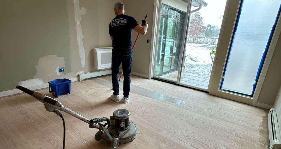 Professional refinishing hardwood floors in a residential space, demonstrating how to keep hardwood floors looking brand new with proper care and maintenance.