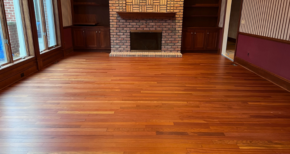 Newly finished hardwood flooring installed by TH Custom Hardwood, showcasing rich wood grain and a smooth, polished surface in a living room.